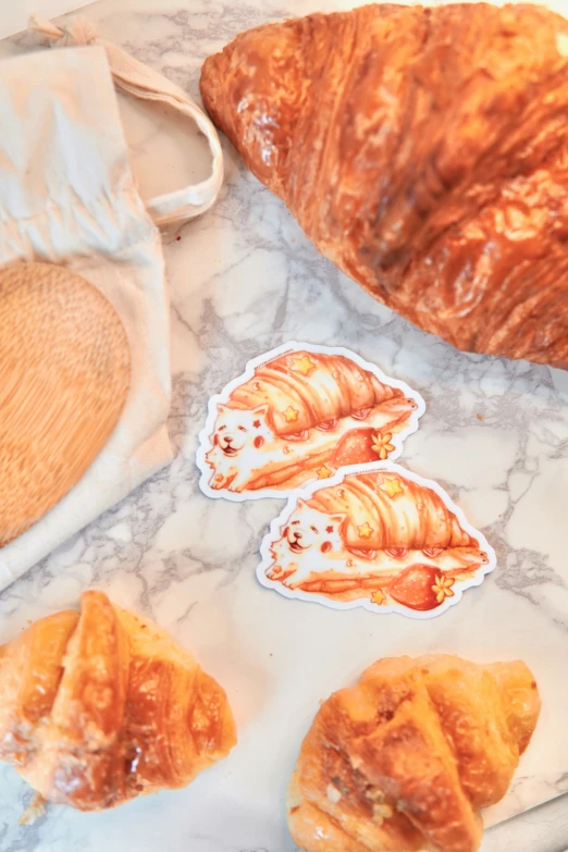 a couple of croissants sitting on a table next to some pastries