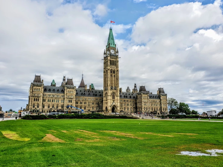 a large building with a spire on top of a grassy field