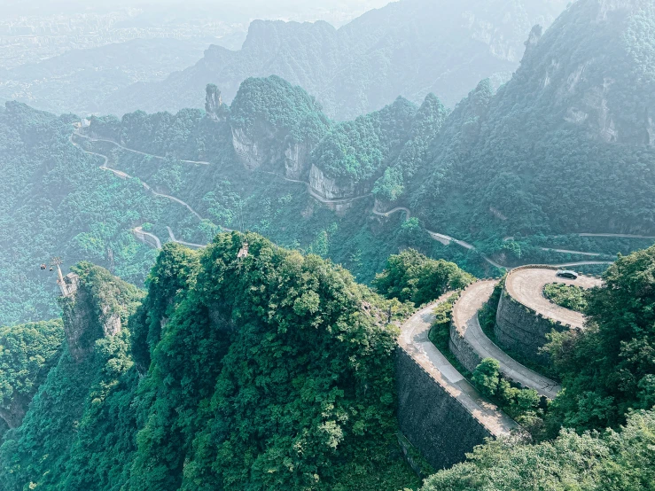 a road surrounded by mountains and greenery