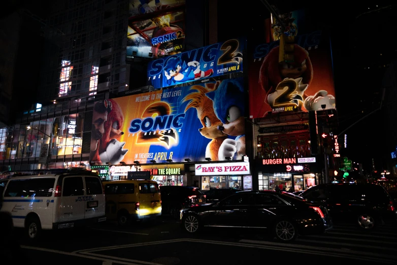 night scene, including a neon building with billboards