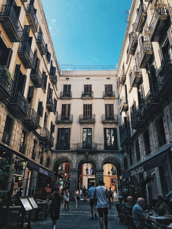 people walking on the sidewalk in an old city