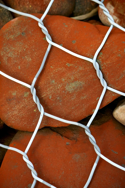 a lot of rocks next to a wire fence