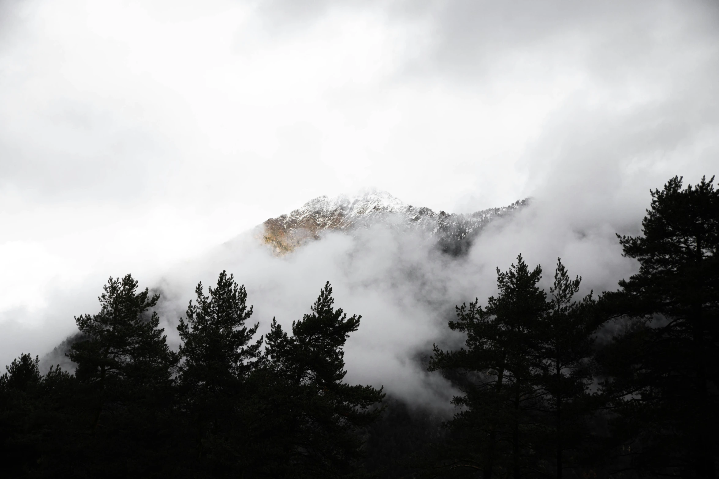 a large mountain sitting above the clouds