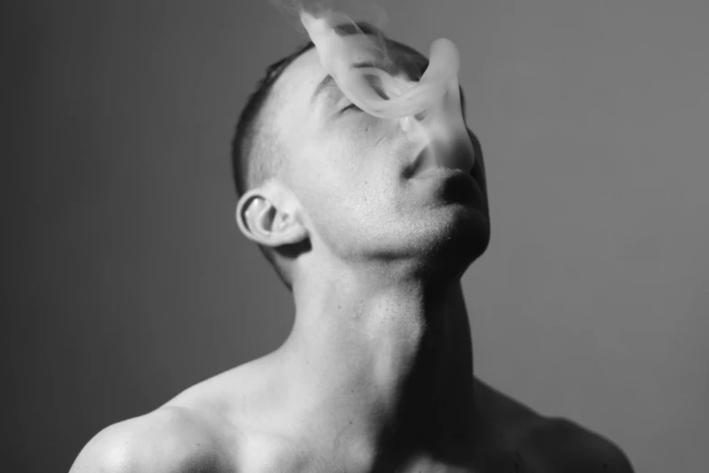 a man that has his nose open and some smoke