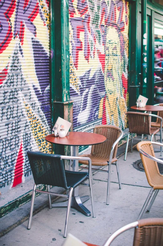 chairs and tables are placed in front of a storefront