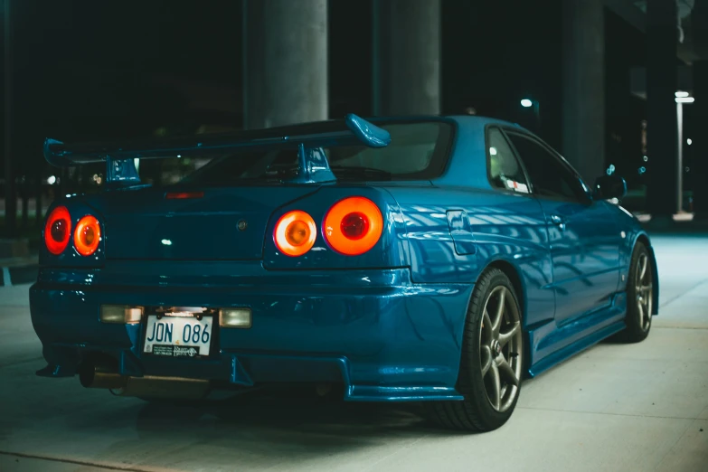 a blue sports car parked in front of some pillars