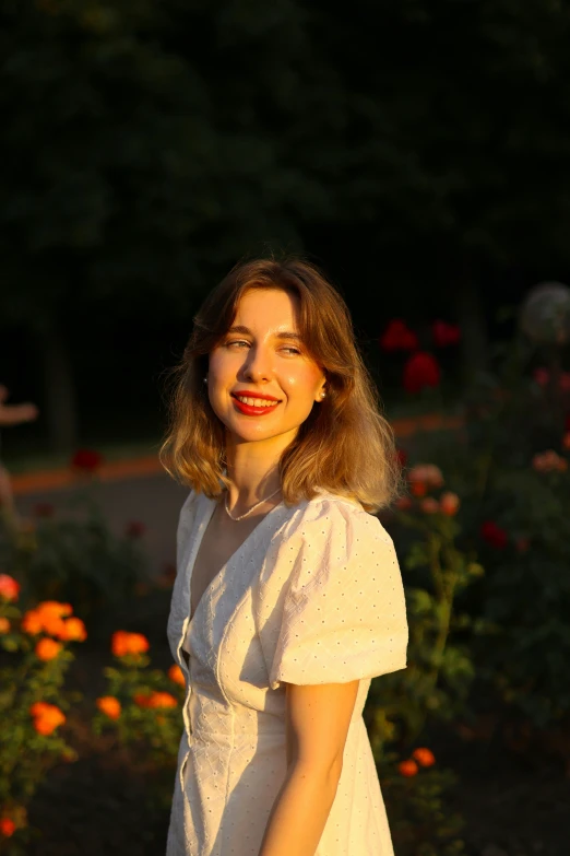 a girl in a white dress smiles while posing for a picture