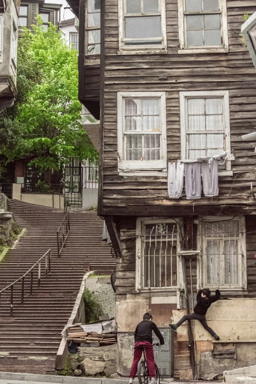 the man is riding his bike near the wooden house