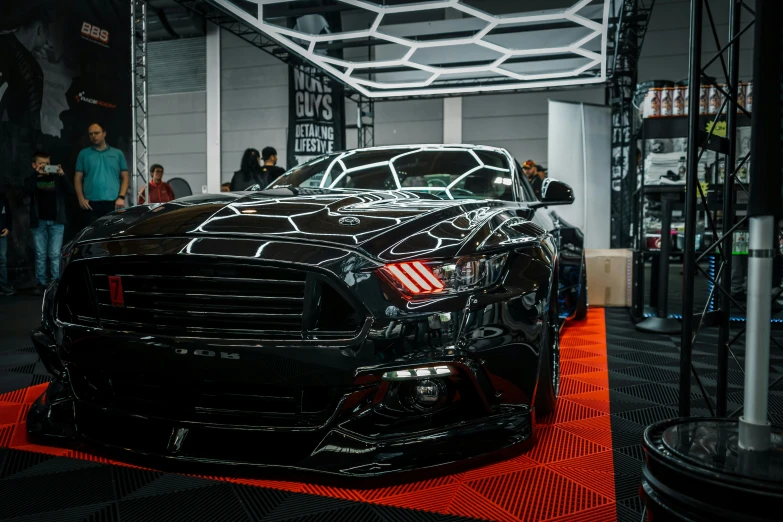 a black mustang car on display at a auto show