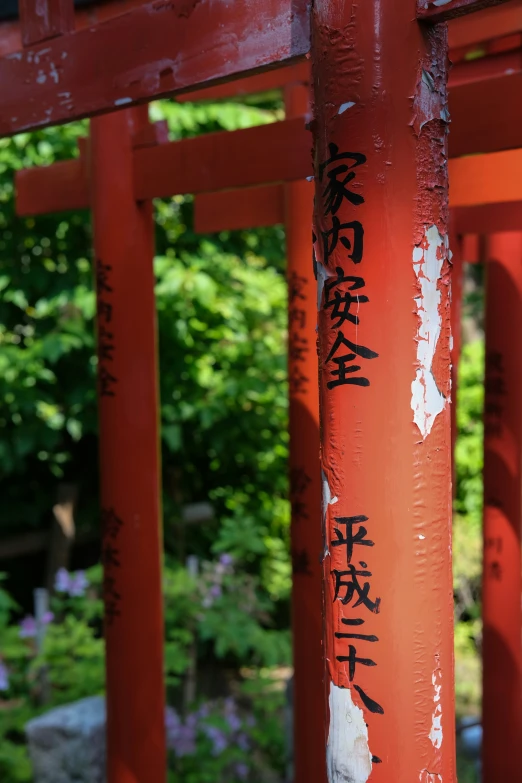 a very tall red pole with graffiti on it
