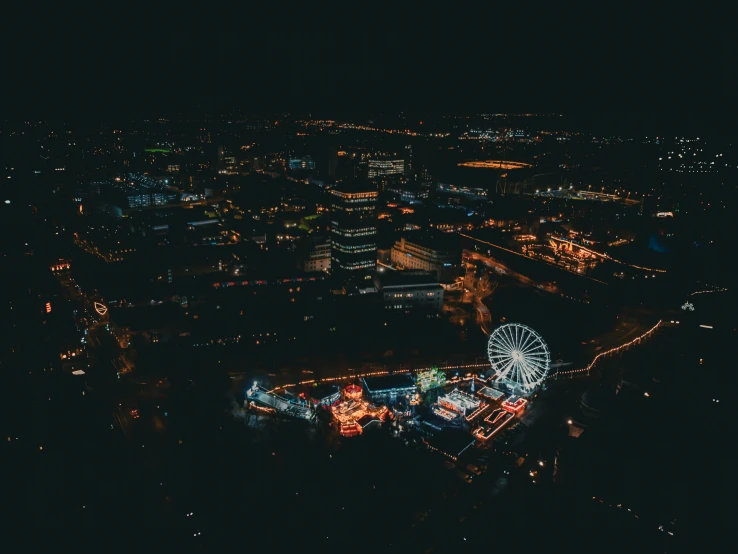 a nighttime view of a carnival with ferris wheel