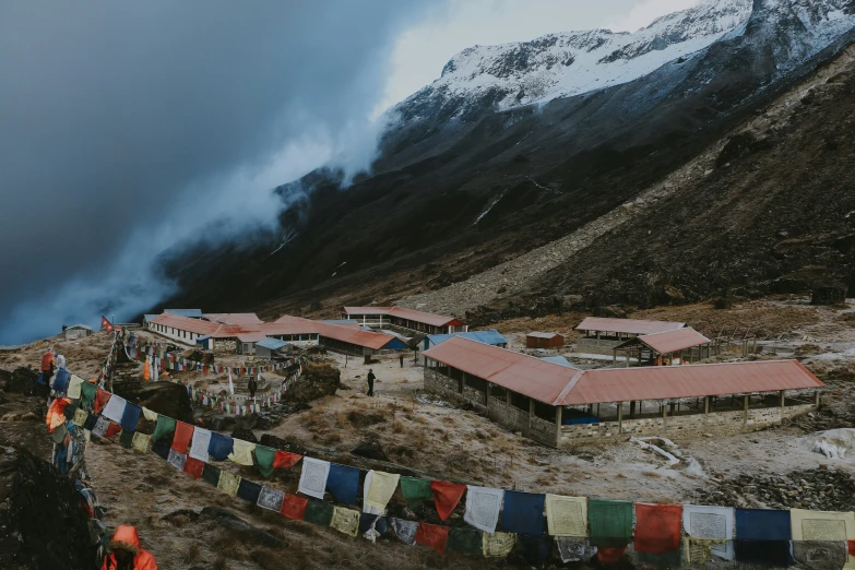 many colorful flags hanging up by the side of a hill