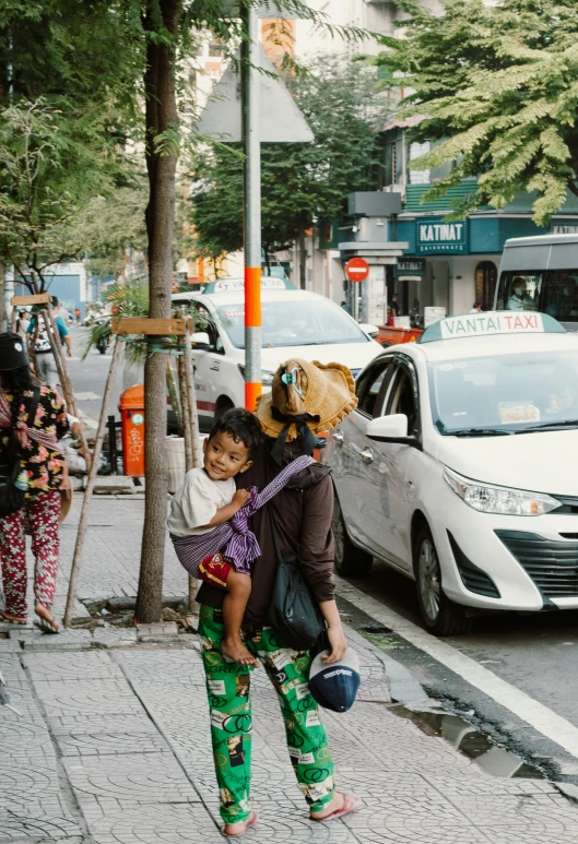 the child is walking down the sidewalk in front of a bus