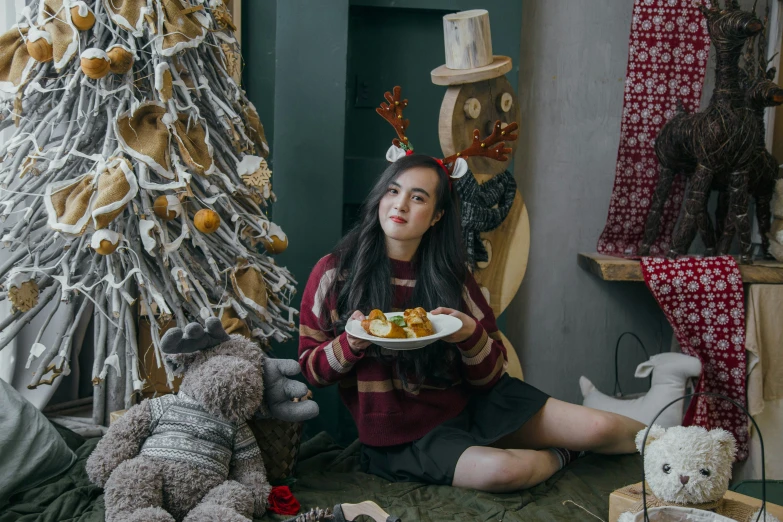 a woman holding a plate with food and stuffed animals on the floor