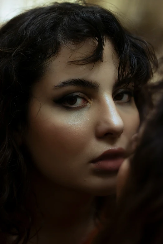 a close up of a woman with her hand on her hair