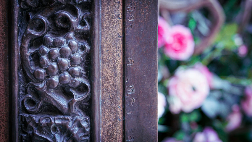 an ornamental wooden door with a beautiful pink flowered background