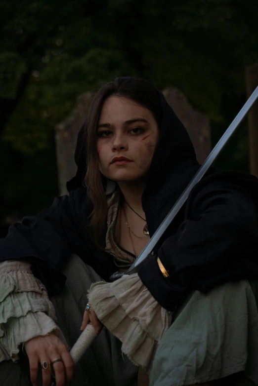 a woman with a sword sitting on a stone