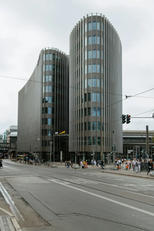 a tall building with curves in front of it on the corner of a street