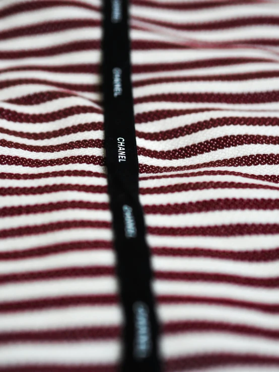close up of a red and white striped shirt with small black letters on it