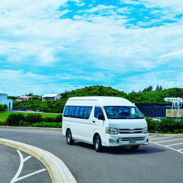 the van is driving down the paved street