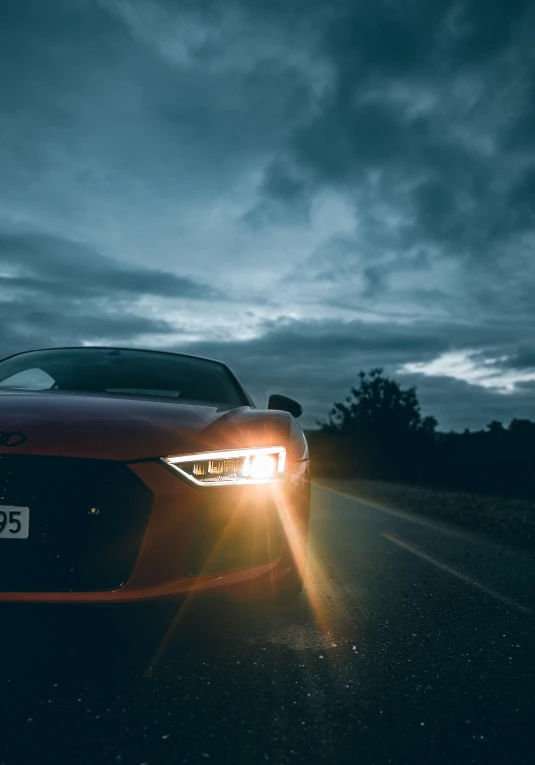 a sports car is driving on a dark highway