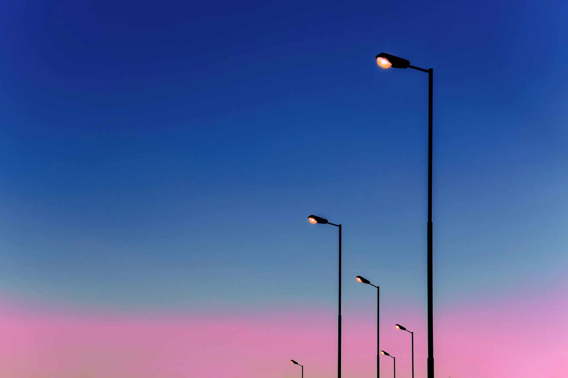 a parking lot is next to many street lamps