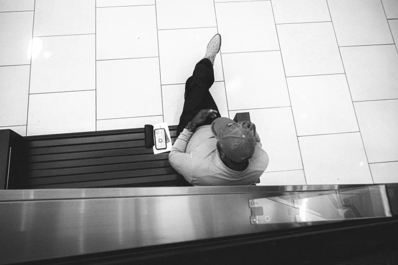 a man is falling down an escalator while wearing a hat