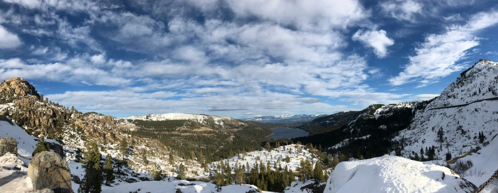 a group of mountain sides covered in snow under clouds