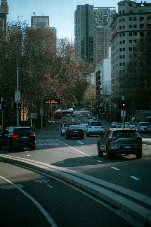 cars parked in a busy city street next to tall buildings