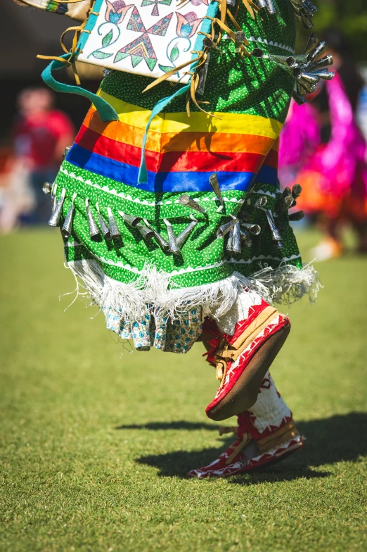 a woman is dressed in mexican clothing and has a colorful shawl on her head