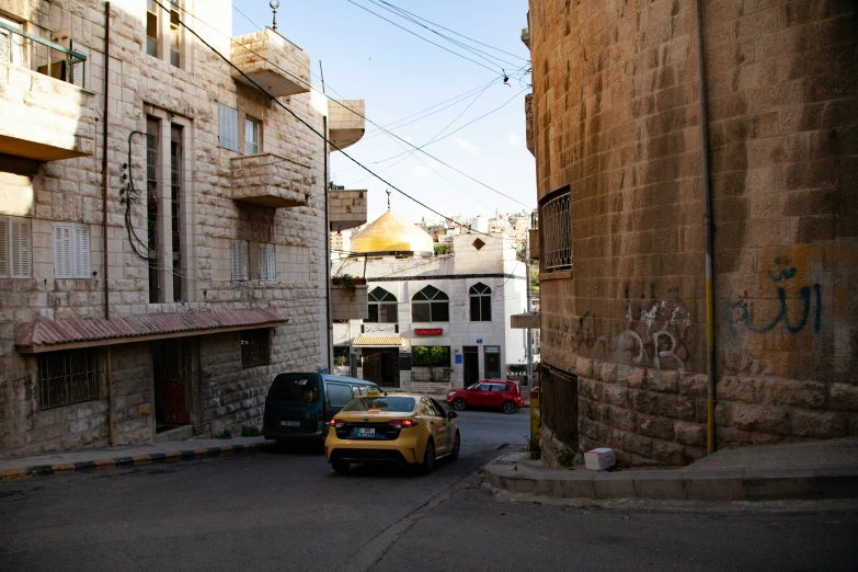 cars parked in an alley near buildings and power lines