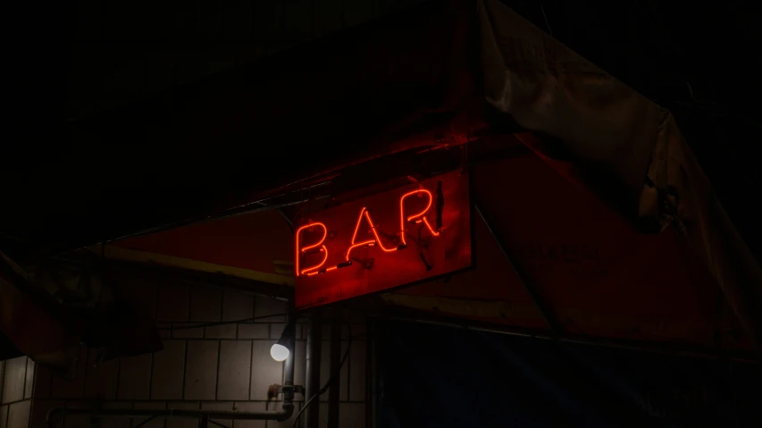 a bar sign lit up in the dark