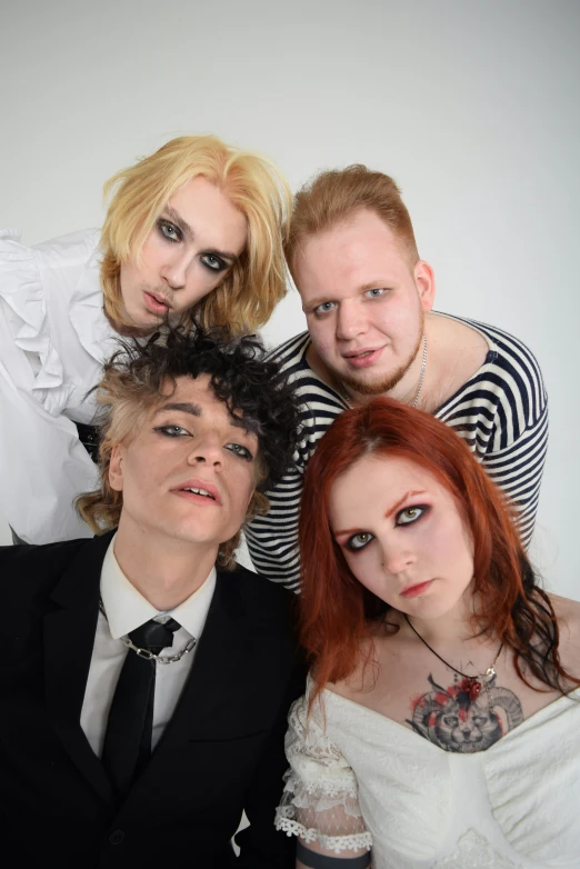 four people are posing for a picture while one man has his head shaved