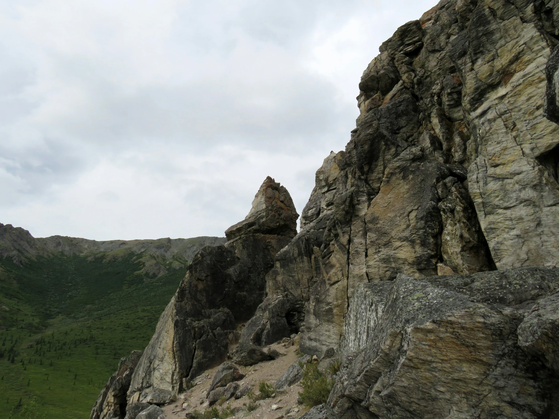 a very large rocky mountain with some grass