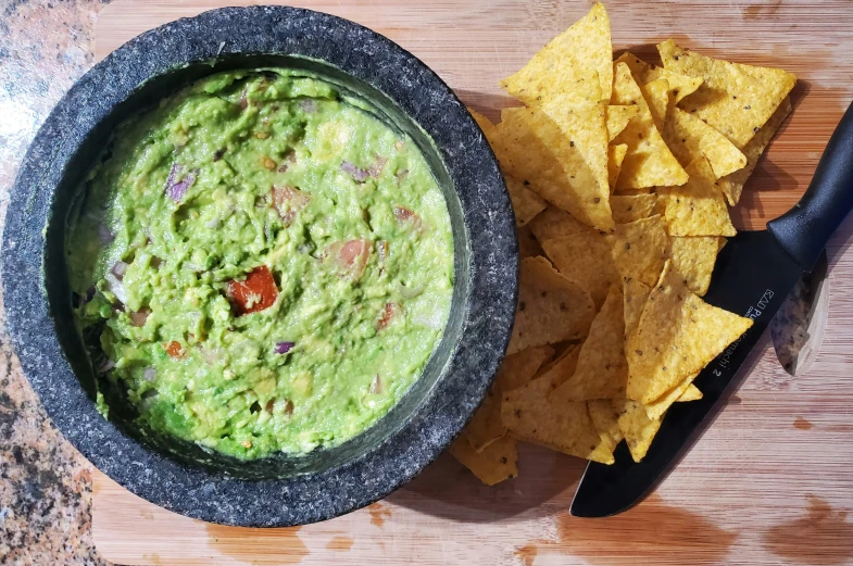 there is a bowl of salsa and chips on the table