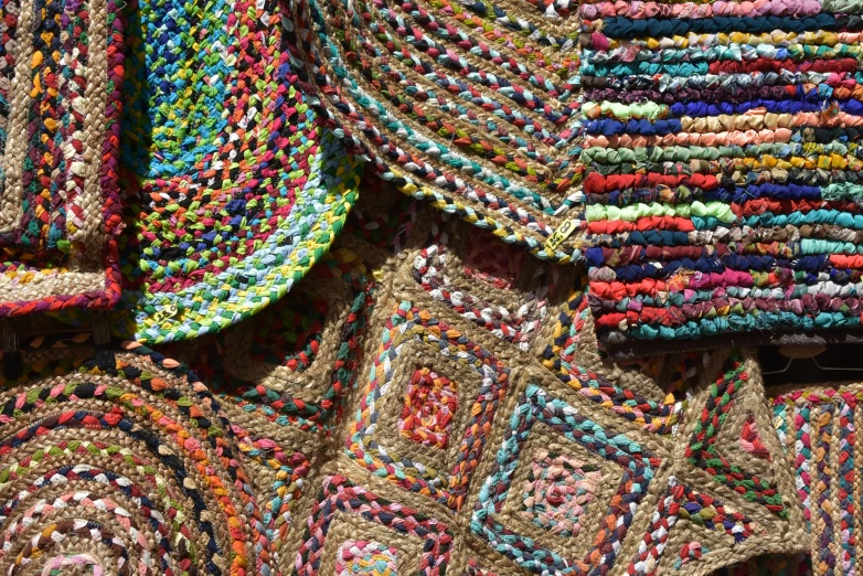 a pile of woven rugs on display at the store