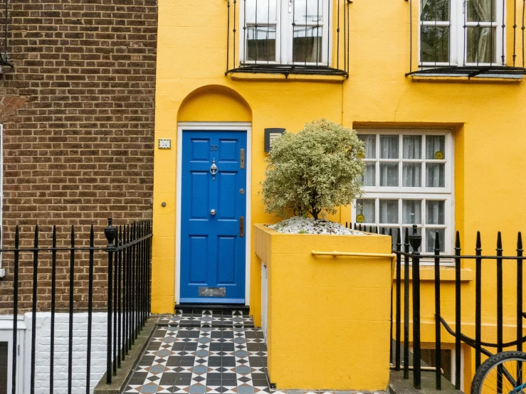 a yellow building with a blue door and windows