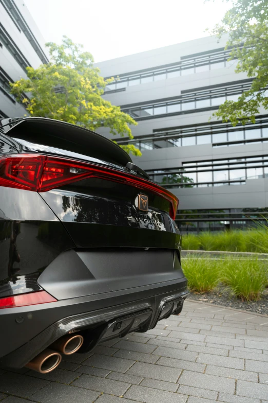 the rear end of a grey and black car