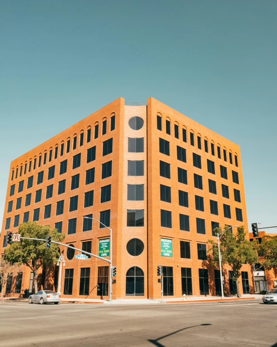 a tall brick building on the corner of an intersection