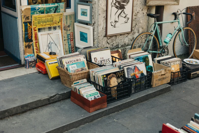 a bicycle leaning up against a building with books and magazines