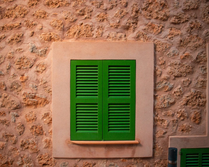 green shutters open on the wall of a building