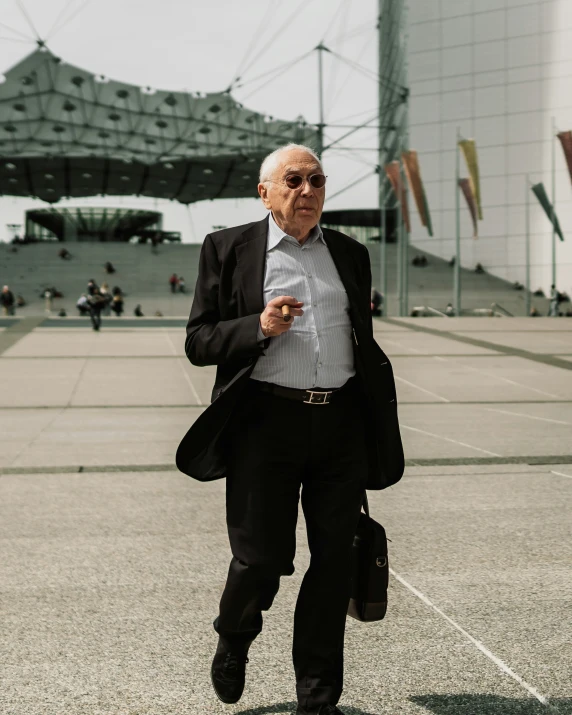 a man in suit and tie walking by a building