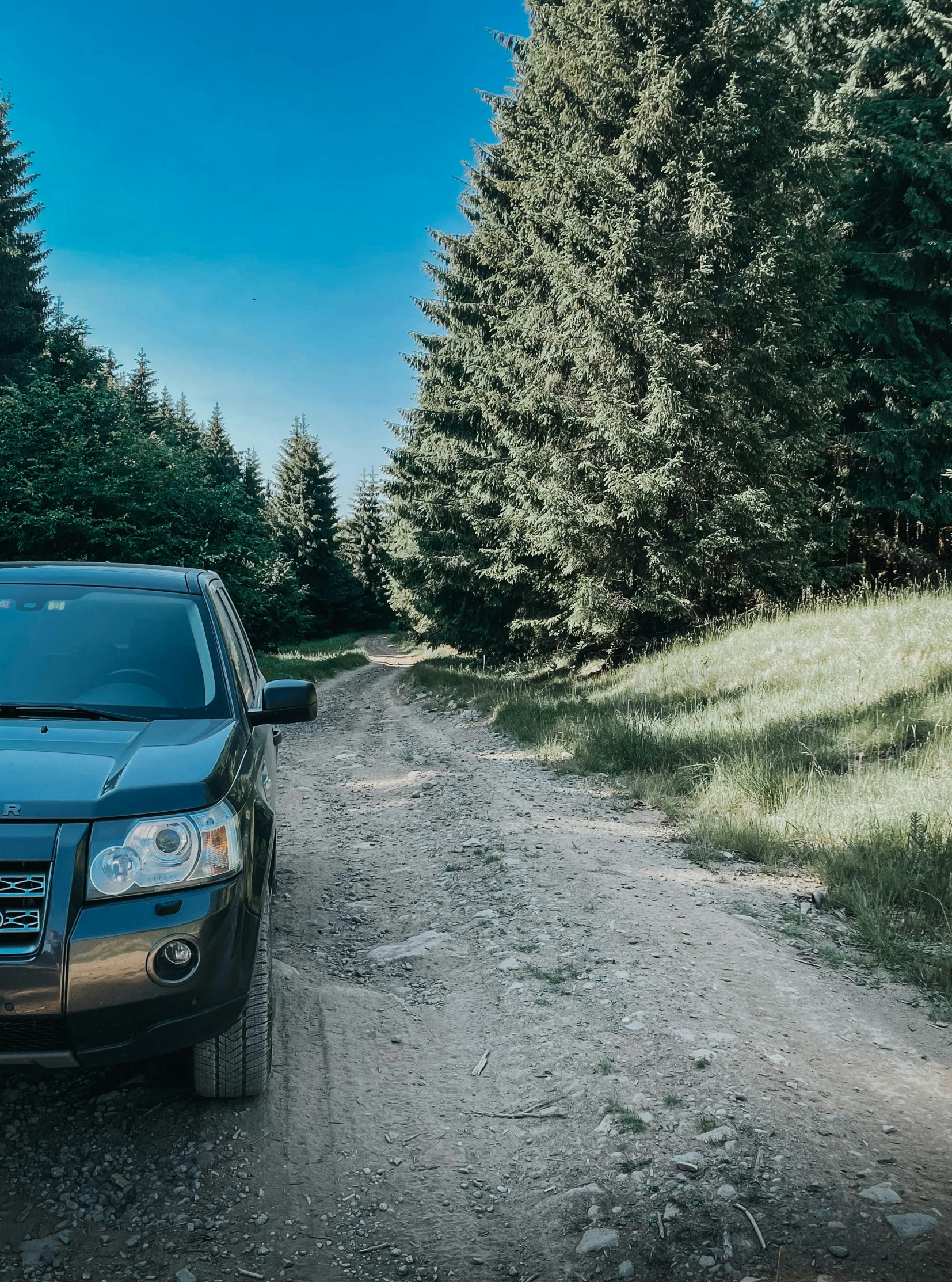 the car is parked in a gravel road