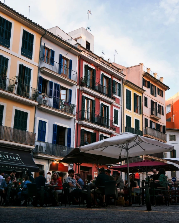 many people standing outside an umbrella covered building