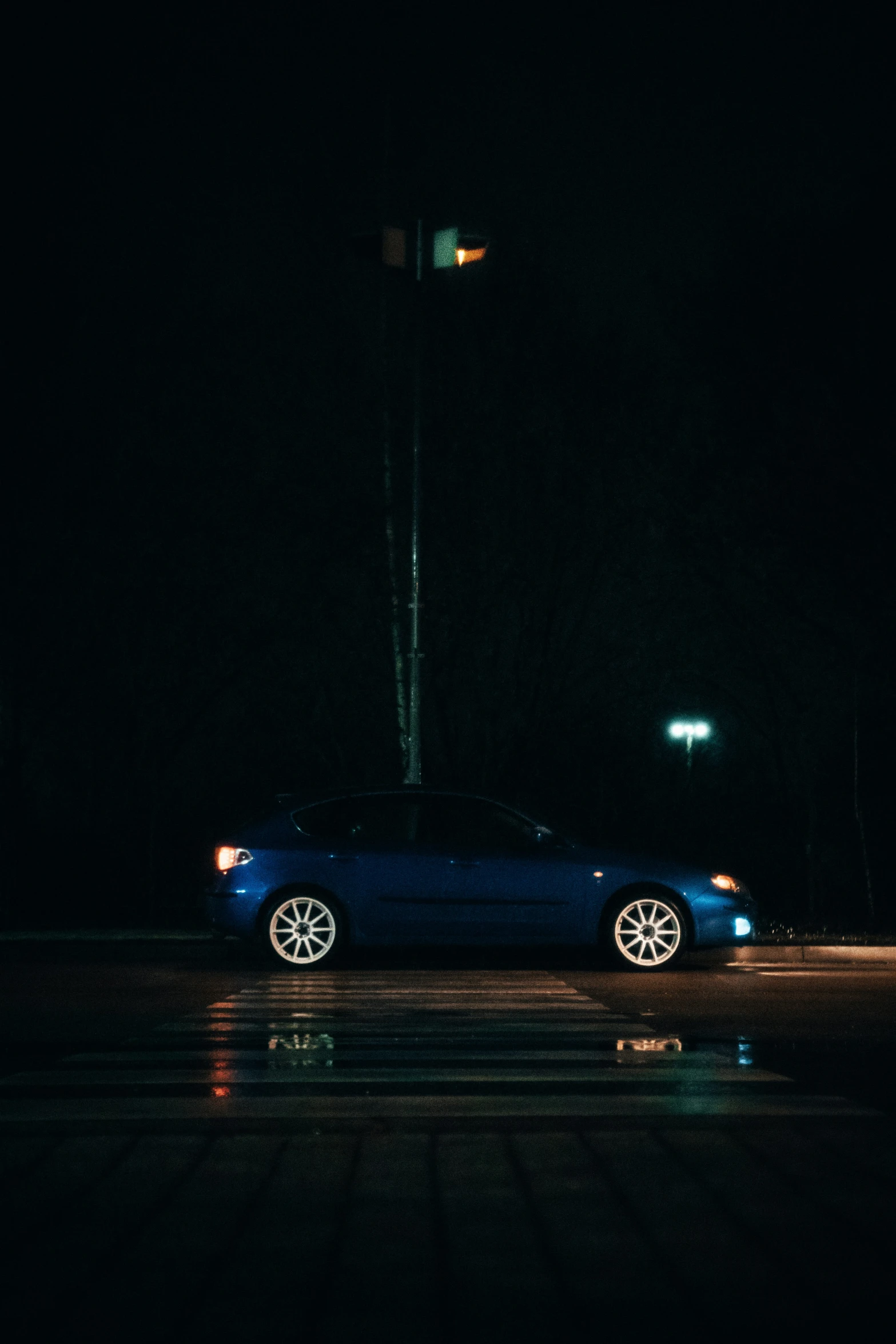 a blue car that is parked at night