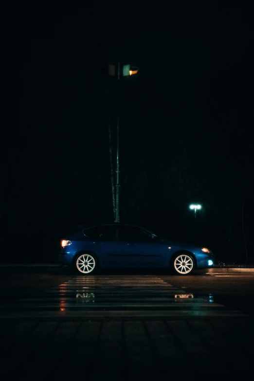 a blue car that is parked at night