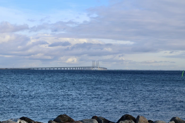 a long bridge on an overcast day near the ocean