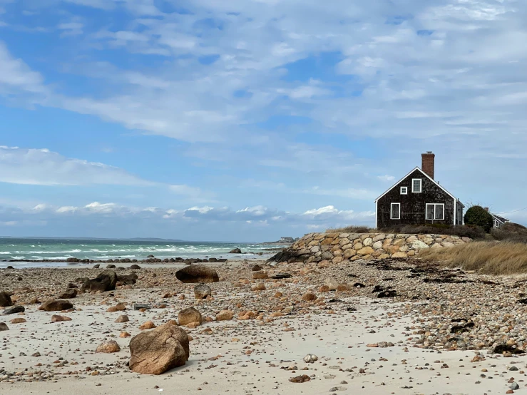 there is a red house on the beach by the ocean