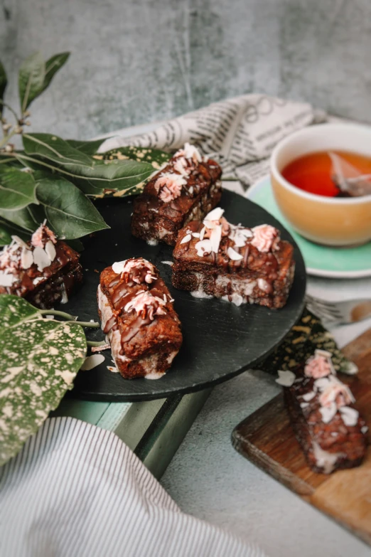 brownies with pink and white icing are stacked on a plate