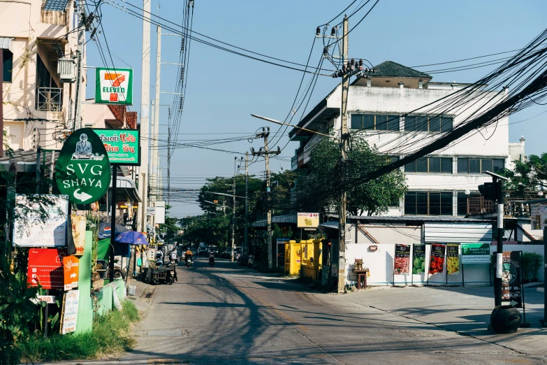 a long city street with buildings, electrical lines, and palm trees